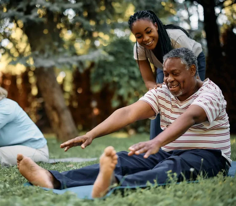 Happy-black-physical-therapist-assists-seniors-during-exercise-class-in-park-1374x1190-1